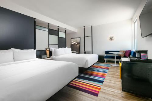 een hotelkamer met 2 bedden en een bureau bij Aloft Dallas Euless in Euless