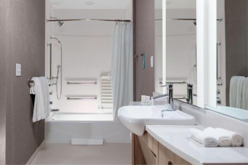 a bathroom with a sink and a tub and a shower at SpringHill Suites By Marriott Durham City View in Durham