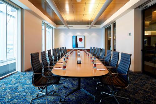 a large conference room with a long table and chairs at Marriott Montreal Airport In-Terminal Hotel in Dorval