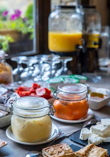 a table topped with jars of jam and food at Roca Blanca in Espot