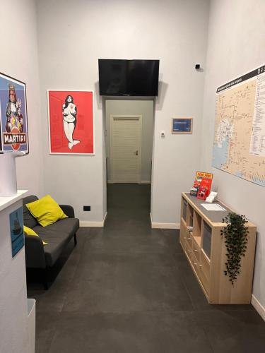 a living room with a couch and a tv on the wall at Cabà bed&breakfast in Naples