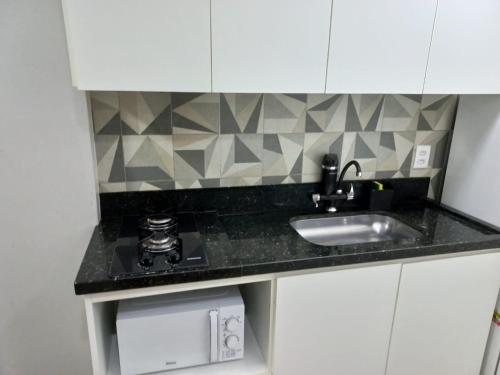 a kitchen with a sink and a counter top at Flat Beverly Hills 101A in Vila Velha