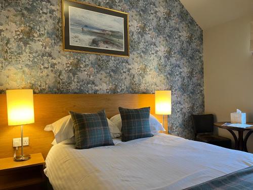 Old Aberlady Inn في أبرليدي: غرفة نوم بها سرير مع مصباحين
