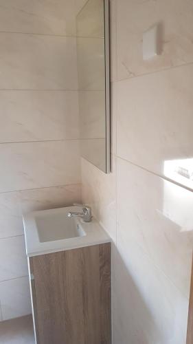 a white bathroom with a sink and a mirror at Isabel de Gouveia in Belmonte