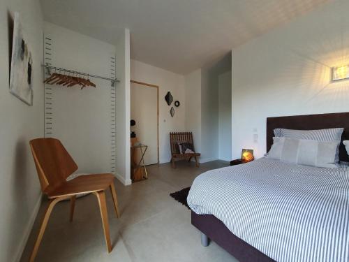 a bedroom with a bed and a chair in it at La Maison d'Elisa in Royan