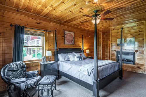 um quarto com uma cama, uma ventoinha e uma cadeira em Knotty By Nature em Sevierville