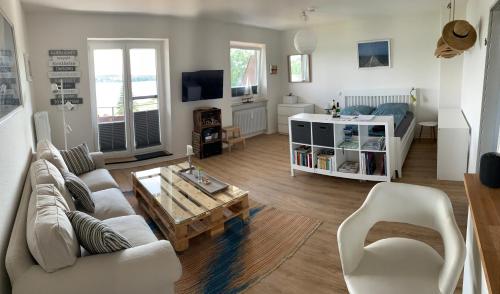 ein Wohnzimmer mit einem Sofa und einem Tisch in der Unterkunft Apartment am See in Scharbeutz
