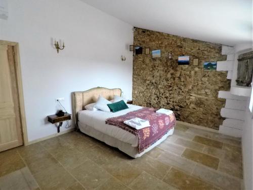 a bedroom with a bed and a stone wall at Castell Granadella in L'Ampolla