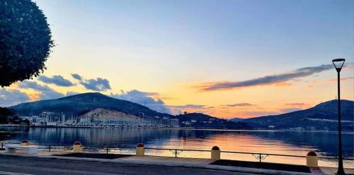 a sunset over a body of water with mountains at Smalis Studios in Lakkíon
