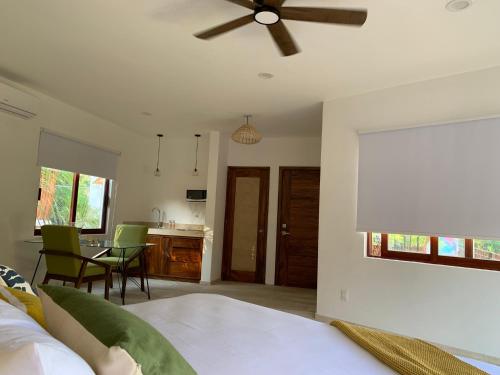 um quarto com uma cama e uma ventoinha de tecto em Luana Suites- Suite Maya em Zihuatanejo