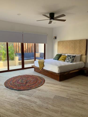 1 dormitorio con 1 cama y ventilador de techo en Luana Suites- Suite Maya, en Zihuatanejo