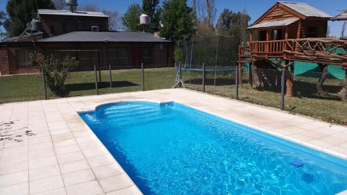 una gran piscina azul en un patio en Tierra India Cabañas en San Rafael