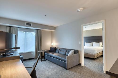 Residence Inn by Marriott Providence Lincoln في لينكولن: غرفة في الفندق مع أريكة وسرير