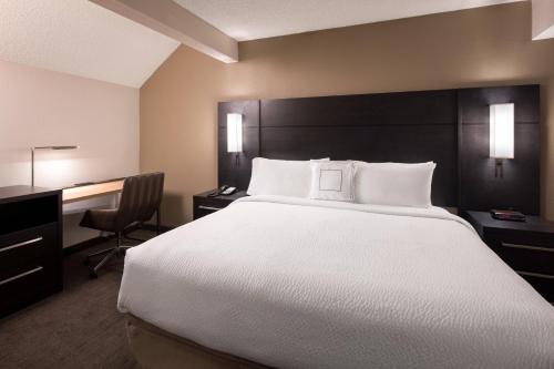 波德的住宿－Residence Inn by Marriott Boulder，酒店客房设有一张大床和一张书桌。