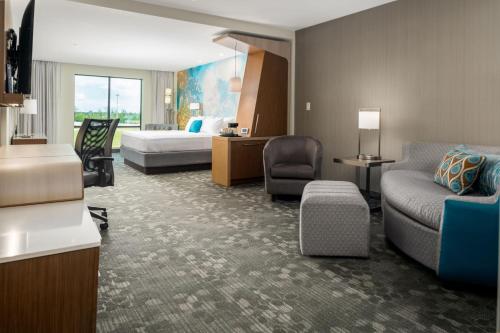 Habitación de hotel con cama y sofá en Courtyard by Marriott Houston Northeast en Houston