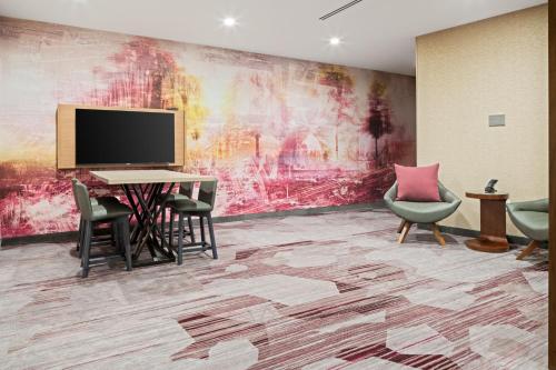 a room with a desk and chairs and a tv at Courtyard by Marriott Houston Northeast in Houston