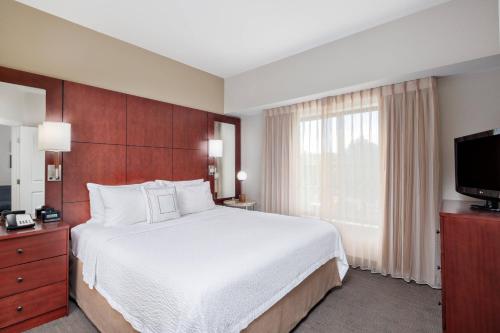 ein Hotelzimmer mit einem Bett und einem TV in der Unterkunft Residence Inn Phoenix NW/Surprise in Surprise
