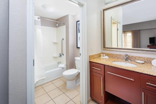 a bathroom with a toilet and a sink and a mirror at Residence Inn Phoenix NW/Surprise in Surprise