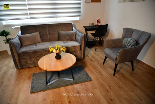 a living room with a couch and a table and chairs at Apartment No 11 in Subotica