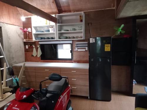 Small cosy house (simple but complete) في Asgad: مطبخ صغير مع دراجة نارية في غرفة