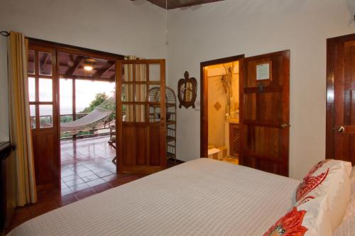 a bedroom with a bed and a door to a patio at Hotel Villas Nicolas - Adults Only in Manuel Antonio