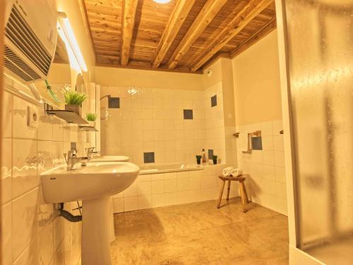 une salle de bain avec un lavabo et une baignoire dans l'établissement Shatzy, à La Rosière