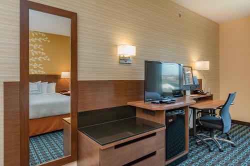 Cette chambre dispose d'un bureau, d'une télévision et d'un lit. dans l'établissement Fairfield Inn & Suites by Marriott Elkhart, à Elkhart