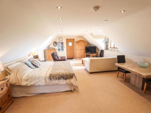 een grote slaapkamer met een bed en een bank bij Granary Loft in Grantham