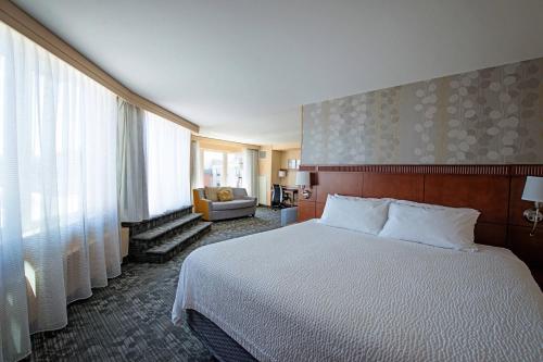 a hotel room with a bed and a chair at Courtyard by Marriott Halifax Downtown in Halifax