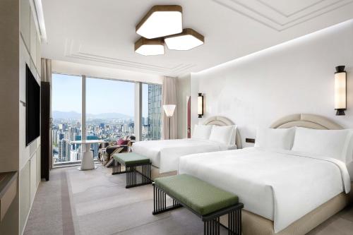 a hotel room with two beds and a large window at Josun Palace, a Luxury Collection Hotel, Seoul Gangnam in Seoul