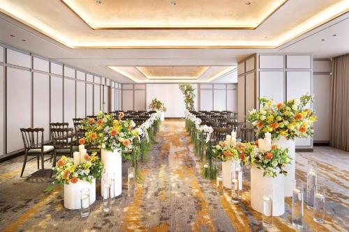 a row of tables and chairs in a room with flowers at Josun Palace, a Luxury Collection Hotel, Seoul Gangnam in Seoul