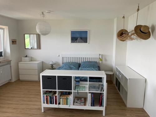 a small bedroom with a bed and a book shelf at Apartment am See in Scharbeutz