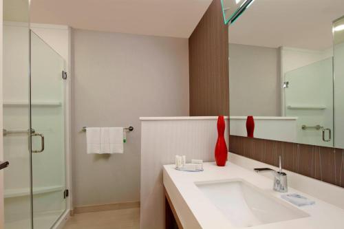 W łazience znajduje się umywalka i lustro. w obiekcie Courtyard by Marriott Victoria w mieście Victoria