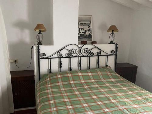 1 cama en una habitación con 2 lámparas en los lados en Beautiful Traditional town house, en Ardales