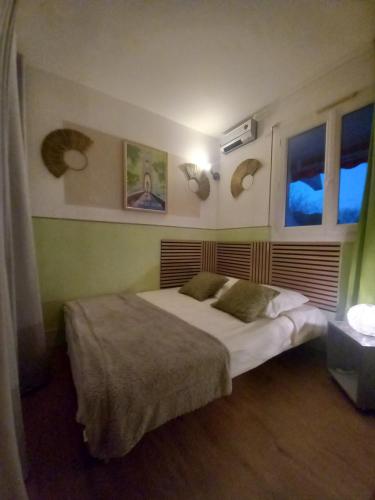a bedroom with a bed and two windows at Rose côté Mer studio et garage, entrée autonome in La Grande-Motte