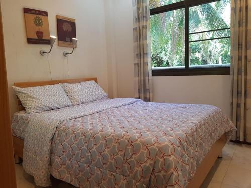 a bedroom with a bed and a window at House in Ban Phe, Thailand in Rayong