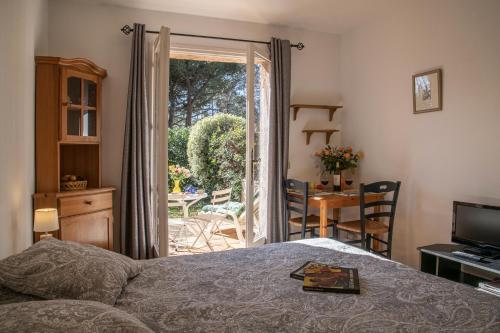 um quarto com uma cama e uma porta para um pátio em Le Mas des Gardettes em Saint-Paul-de-Vence