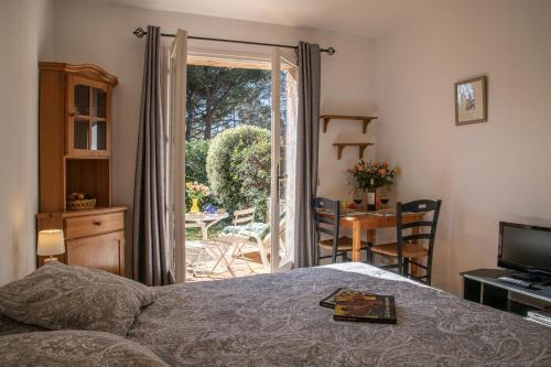 een slaapkamer met een bed en een deur naar een patio bij Le Mas des Gardettes in Saint-Paul-de-Vence