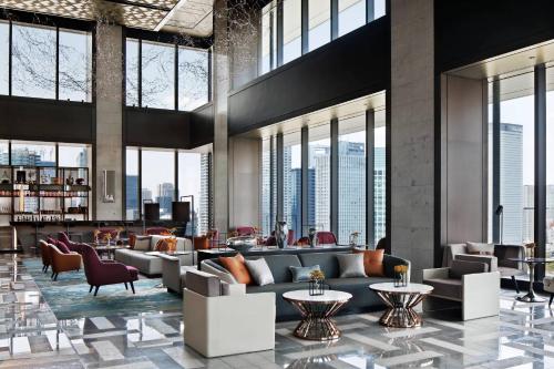 a lobby with couches and tables and windows at mesm Tokyo, Autograph Collection in Tokyo