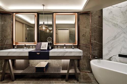 a bathroom with two sinks and a tub and a bath tub at mesm Tokyo, Autograph Collection in Tokyo