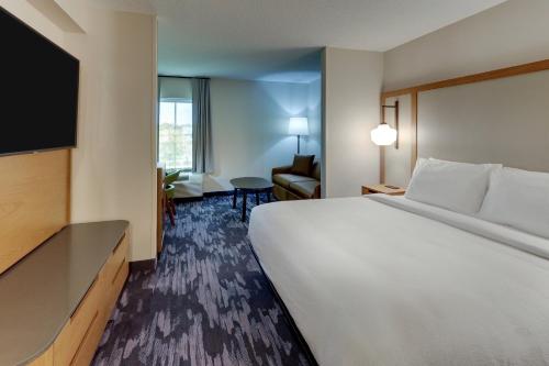a hotel room with a large bed and a flat screen tv at Fairfield Inn & Suites Southport in Southport