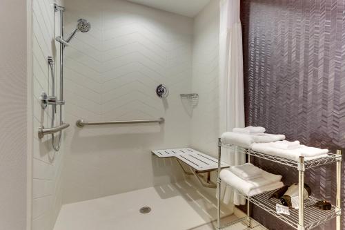 a white bathroom with a shower and a sink at Fairfield Inn & Suites Southport in Southport