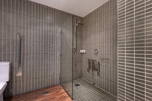 uma casa de banho com um chuveiro e uma porta de vidro em AC Hotel Palacio Universal by Marriott em Vigo