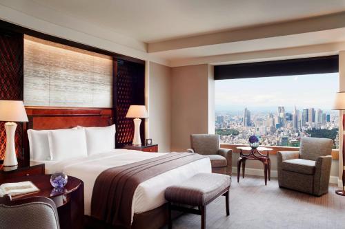 a hotel room with a bed and a large window at The Ritz-Carlton, Tokyo in Tokyo