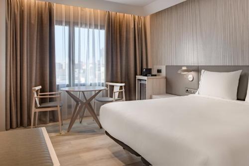 a hotel room with a bed and a table and a window at AC Hotel by Marriott Tenerife in Santa Cruz de Tenerife