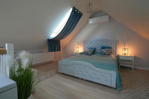 ein Schlafzimmer mit einem blauen Bett und einem Fenster in der Unterkunft CICHAta Nad Zatoką in Cammin in Pommern