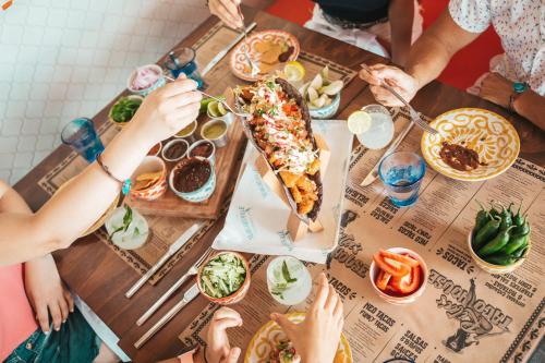 a group of people sitting around a table eating pizza at Margaritaville Island Reserve Riviera Cancún - A Karisma All-Inclusive Experience for All in Puerto Morelos