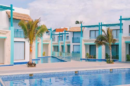 a hotel with a swimming pool in front of buildings at Margaritaville Island Reserve Riviera Cancún - A Karisma All-Inclusive Experience for All in Puerto Morelos
