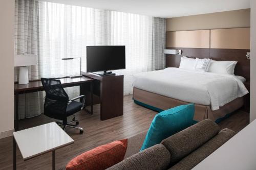 ein Hotelzimmer mit einem Bett und einem Schreibtisch mit einem TV in der Unterkunft Residence Inn Washington Capitol Hill/Navy Yard in Washington