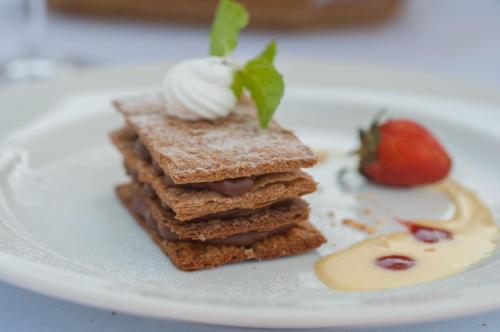 a stack of brownies on a plate with a strawberry at Angkor Palace Resort & Spa in Siem Reap